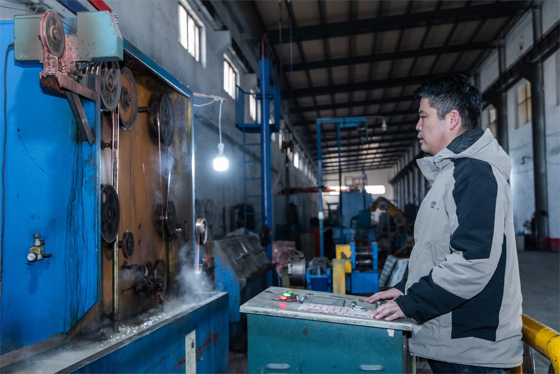Operator working at cable manufacturing equipment in Huada's factory